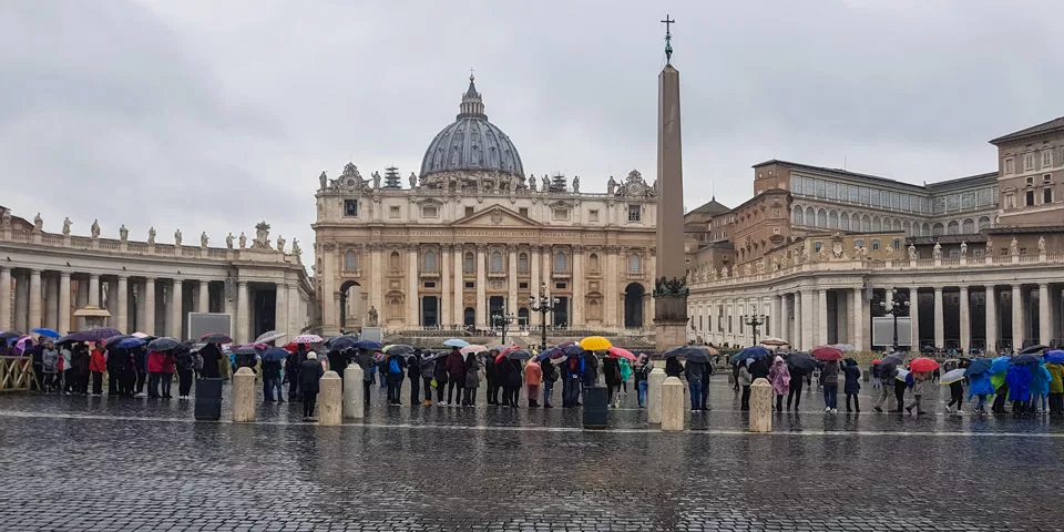 Rainy day in Rome tourists under umbrellas stand in line to visit the Vatican
