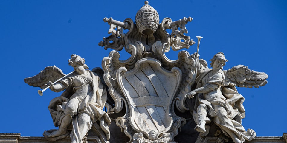 Die Papsttiara und das heraldische Wappenschild auf dem Trevi-Brunnen