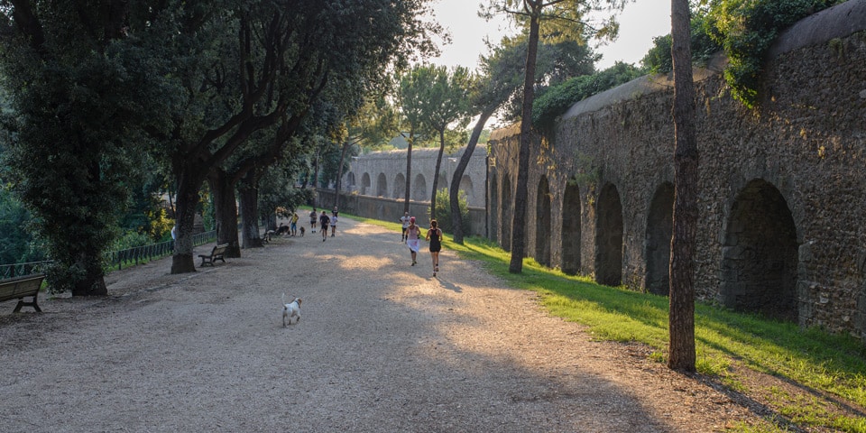 Runners beside the arcades of the Trajan-Paul aqueduct in Villa Doria Pamphilj