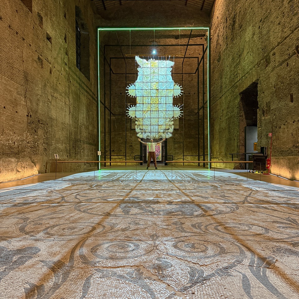 Contemporary art installation inside a vast ancient brick hall of the Baths of Diocletian, Rome