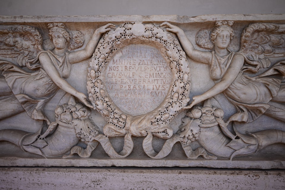 Ancient Roman marble relief with winged Victories holding an inscribed wreath, cloister of the Baths of Diocletian, Rome