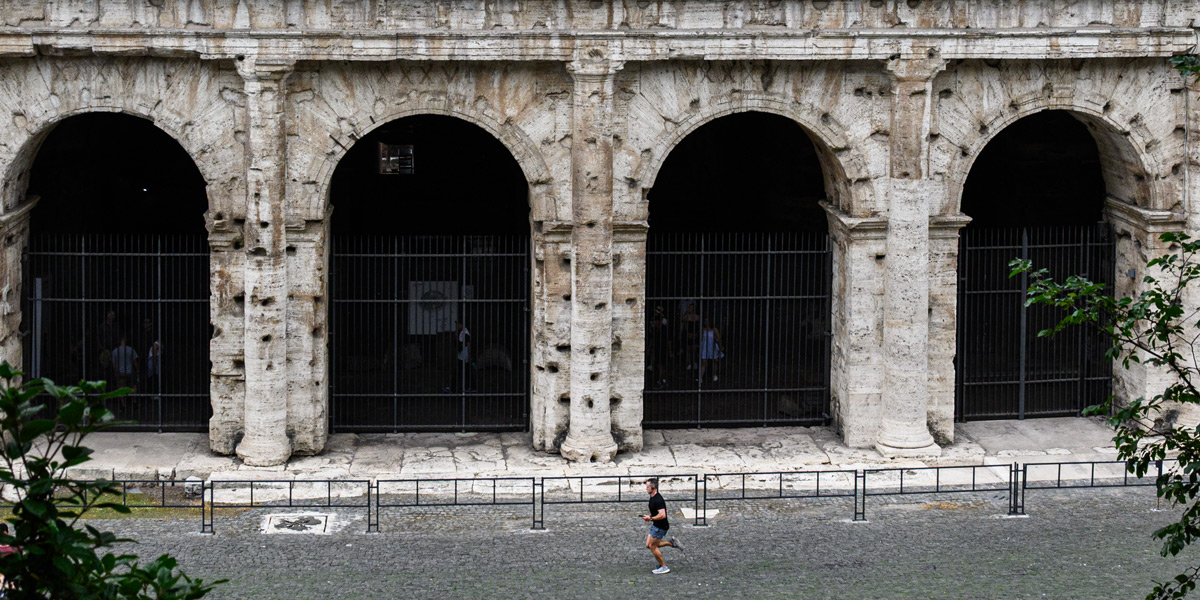 Four Colosseum entrances numbered XXXV to XXXVIII with a runner passing in front for scale