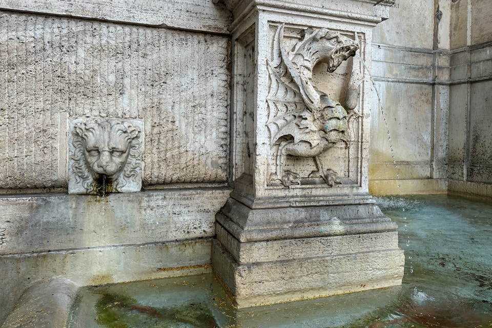 Dragón heráldico de los Borghese expulsando agua y máscara de león en el Fontanone di Ponte Sisto, Piazza Trilussa, Roma