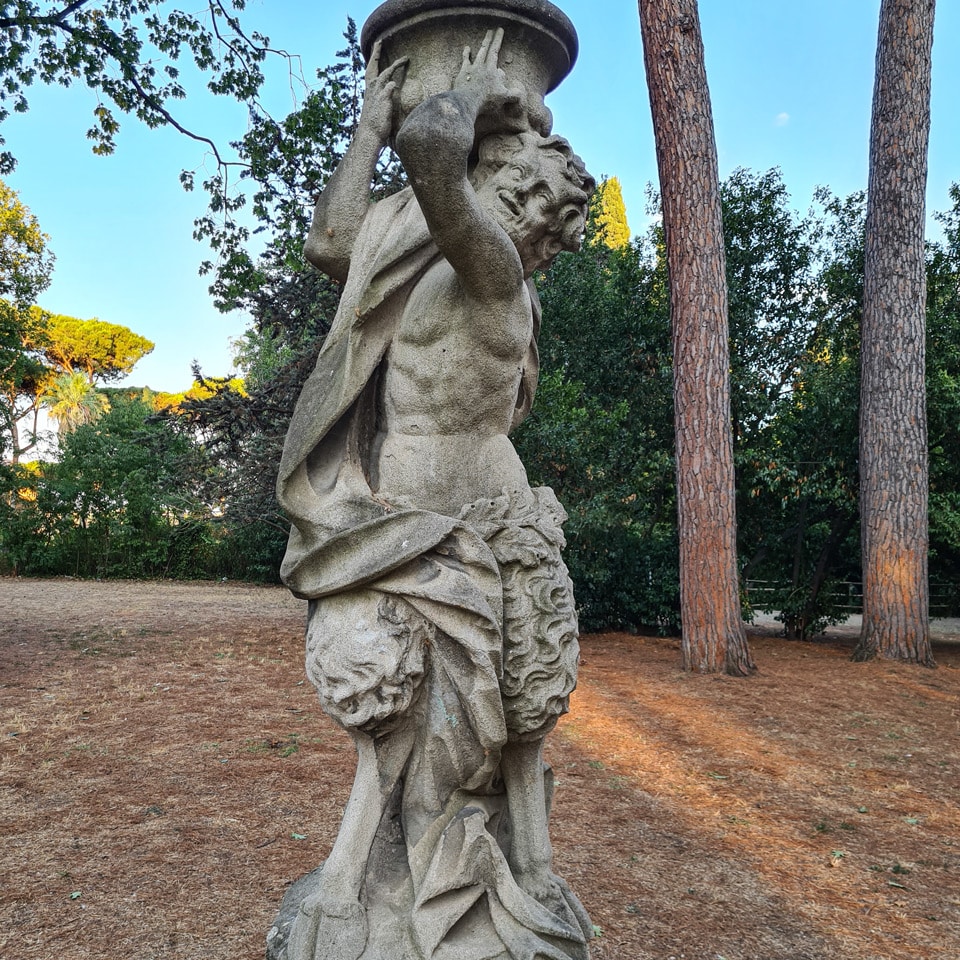 Sandstone satyr with goat legs carrying a garden vase at Villa Sciarra in Rome